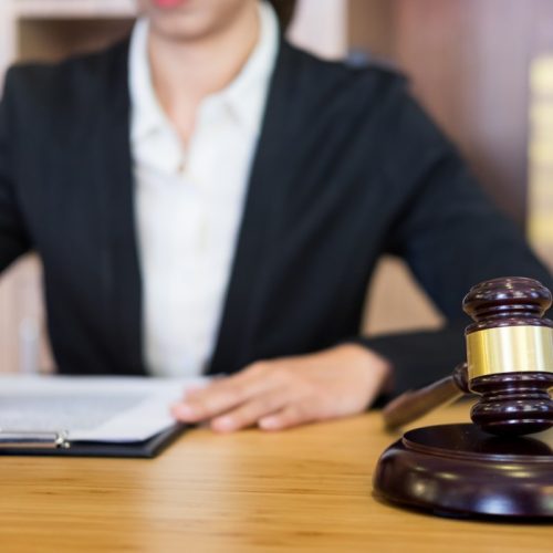 lawyer-judge-reading-documents-at-desk-in-courtroom-working-on-wooden-desk-background-gavel-golden_t20_yXraB6