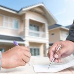 Hand at the close of a sign to contact the apartment house.
