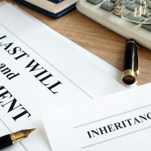 Inheritance tax and last will and testament on a desk.